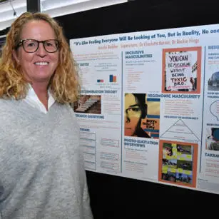 Amelia Beddoe standing with research poster