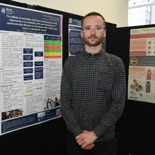 Daniel Copper standing with research poster