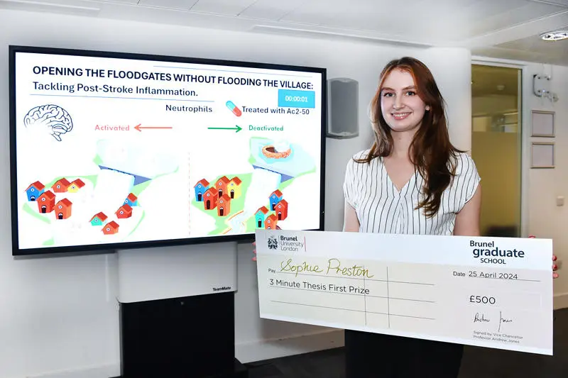 Sophie Preston holding a cheque beside her presentation