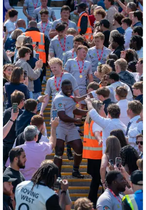 Brunel Rugby Team wearing medals, walking down steps and being congratulated by fans