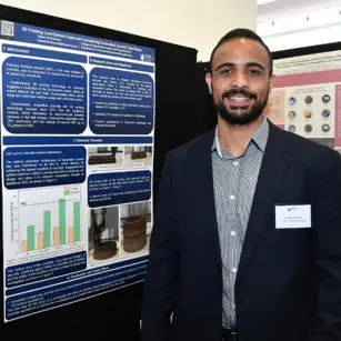 Yazeed Al-Noaimat standing with research poster